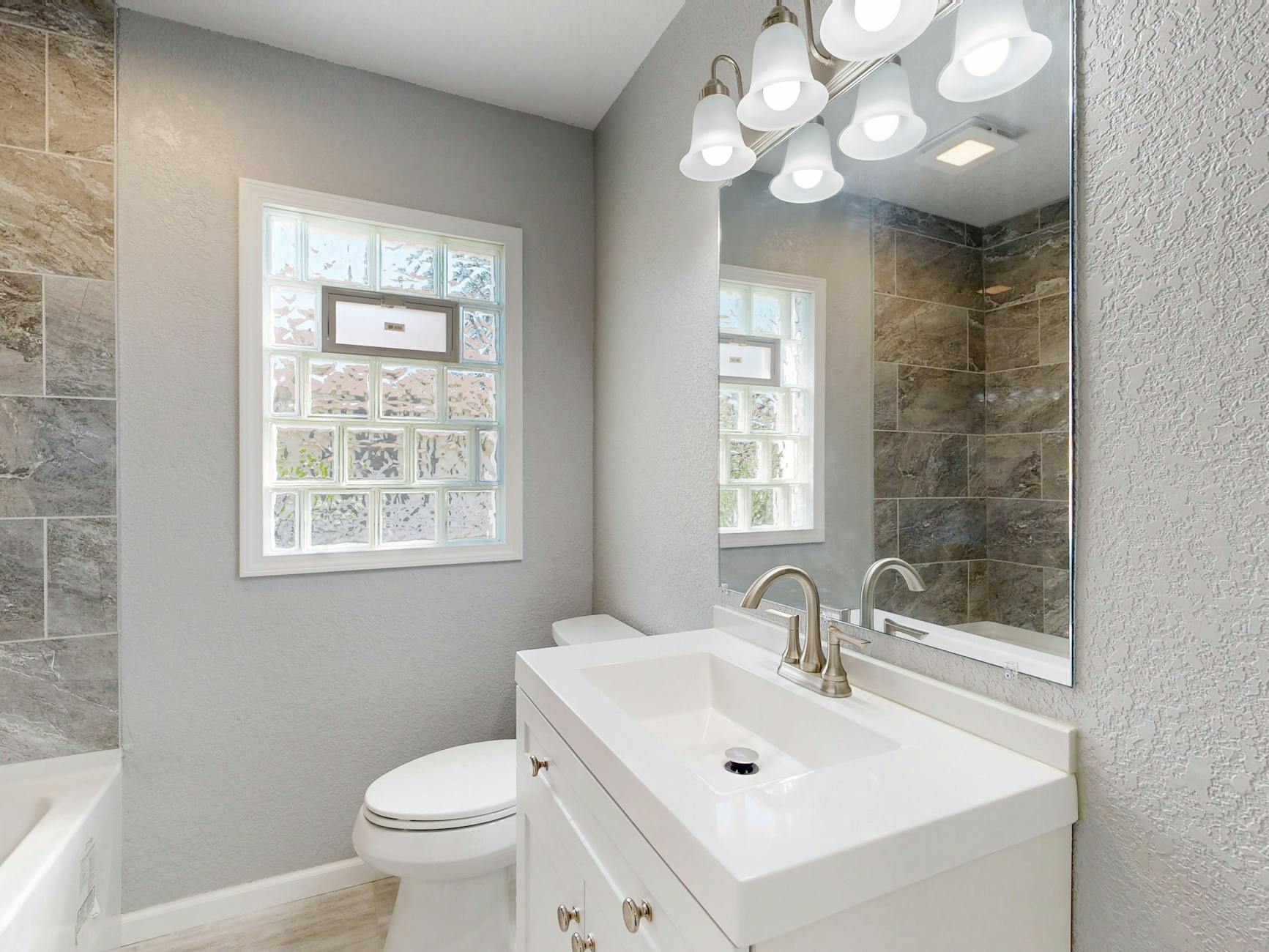 Maprimeadapt' : 3 alertes essentielles pour protéger les seniors des dérives en adaptation logement 4 Salle de bain moderne et lumineuse adaptée aux seniors avec douche accessible et barres d'appui